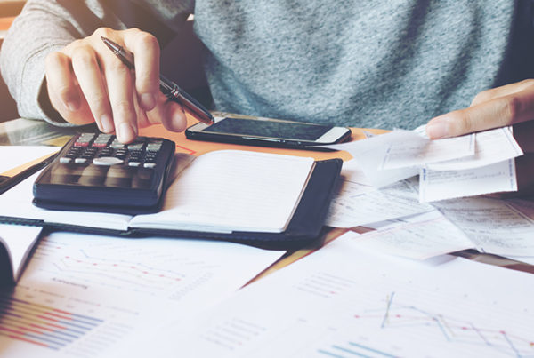 Financial adviser in Nottingham going over financial reports with a calculator